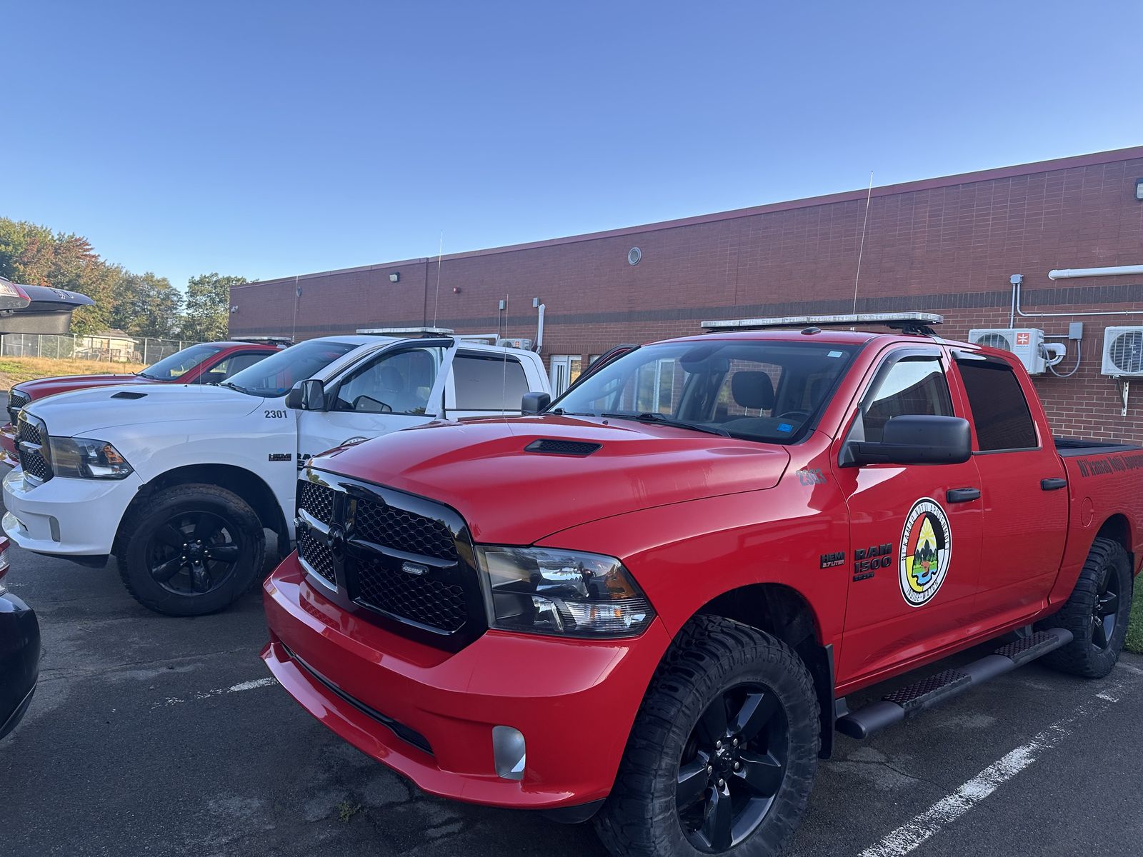 Freshly detailed fleet of red and white pickup trucks parked outside a commercial building