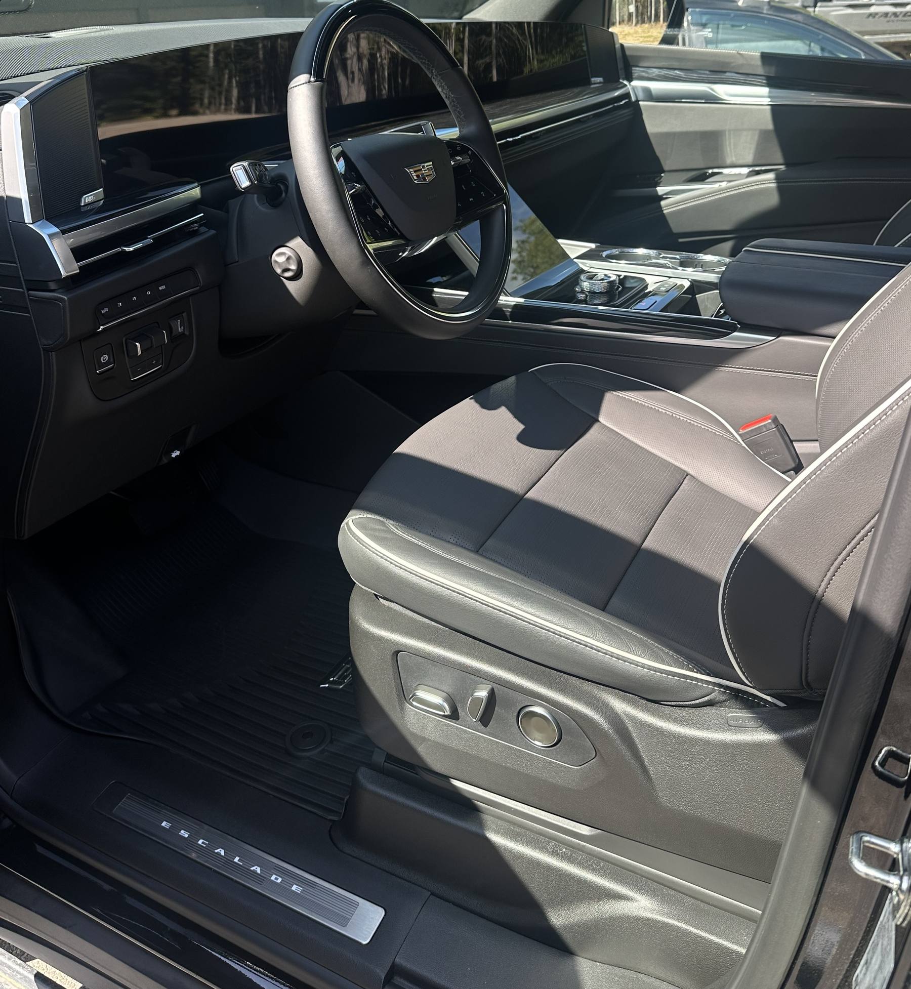 Glossy, freshly detailed Cadillac Escalade interior with steering wheel, dashboard, and front seats
